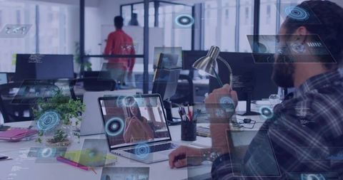 Bearded man holding lamp for remote video call with holographic UI in modern office