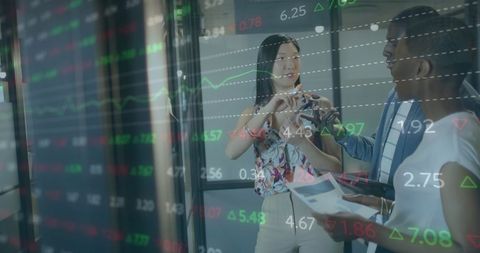 Diverse Professionals Analyzing Digital Stock Market Data in Office