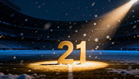 Glowing gold number 21 on snowy stadium turf under spotlight at night