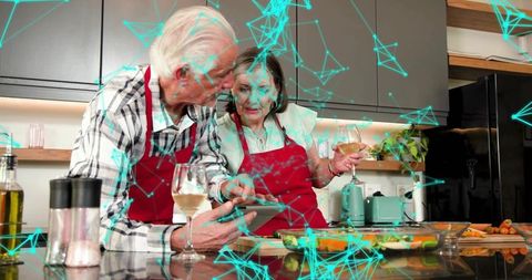Senior couple cooking together using tablet while holding wine glasses, digital overlay