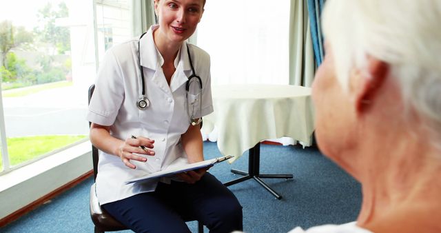 Professional nurse caring for senior patient indoors, smiling confidently - Download Free Stock Images Pikwizard.com