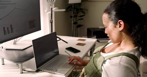 Concentrated remote worker analyzing graphs in modern home office