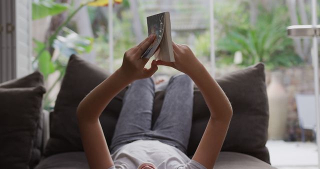 Relaxed Child Reading Book While Lying on Sofa at Home - Download Free Stock Images Pikwizard.com