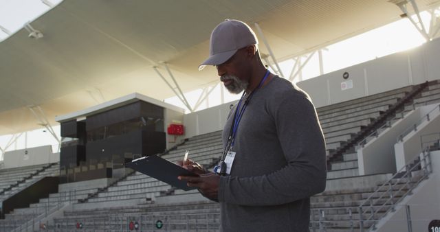 Coach Taking Notes in Empty Sports Stadium - Download Free Stock Images Pikwizard.com