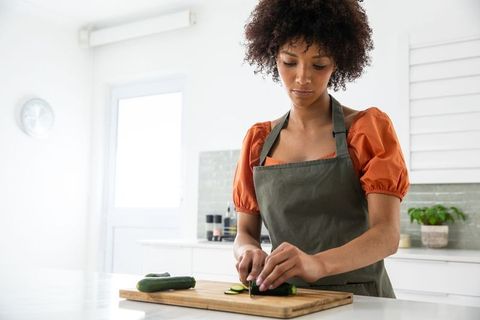 Woman Slicing Vegetables in Bright Modern Kitchen