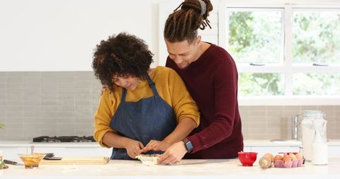 Couple Baking Together in Bright Modern Kitchen Shaping Dough and Sharing Warm Moment