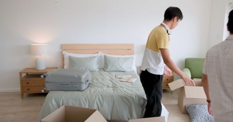 Father and son packing bedroom for moving day together
