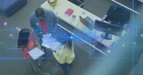 Coworkers collaborating and reviewing documents around desk from above with digital overlay