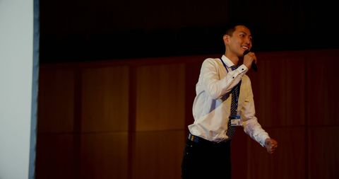 Confident young businessman giving presentation in auditorium