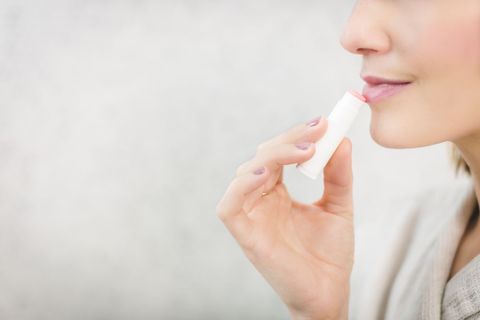 Woman Applying Lip Balm for Soft Lips Close-up
