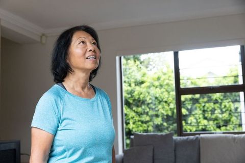 Senior Woman Relaxing at Home, Embracing Tranquility and Comfort Near Window