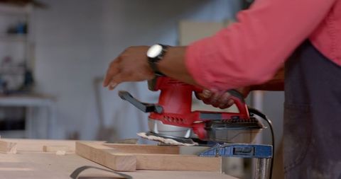 Craftsman Sanding Wood Plank at Carpentry Workshop