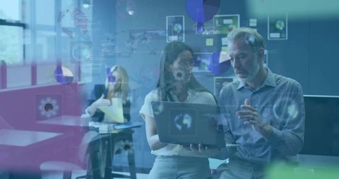 Business team collaborating over laptop with transparent data analytics overlay