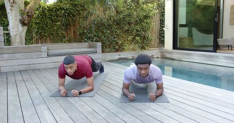 Diverse Male Friends Exercising Outdoors Beside Pool