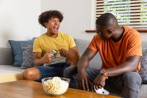 Diverse Friends Enjoy Gaming and Relaxation in Living Room