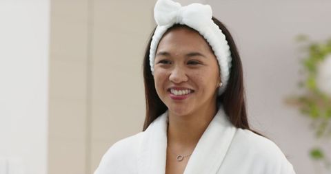 Smiling Woman in Plush Bathrobe Relaxing in Spa Setting