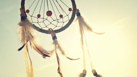 Dreamcatcher against sunset sky capturing sunlight