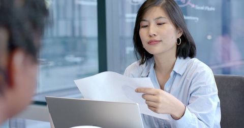 Businesswoman Discussing Document in Modern Office