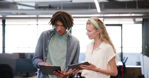 Diverse colleagues collaborating on project in modern office environment