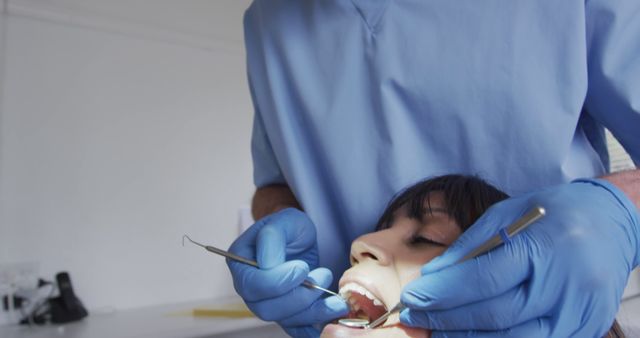 Dentist Treating Patient in Clinic with Blue Gloves and Tools - Download Free Stock Images Pikwizard.com