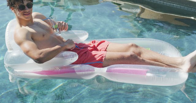 Man Relaxing on Inflatable Pool Lounge with Refreshing Drink - Download Free Stock Images Pikwizard.com