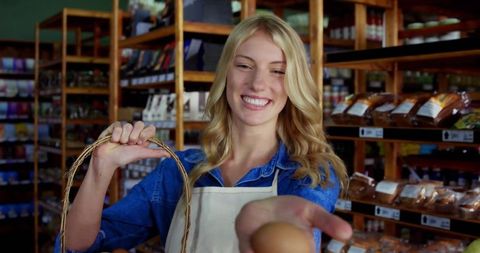 Friendly Store Clerk Offering Fresh Egg in Rustic Grocery Aisle