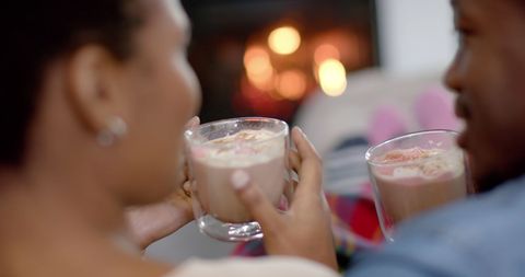 Couple Enjoying Hot Cocoa Together by Cozy Fireplace