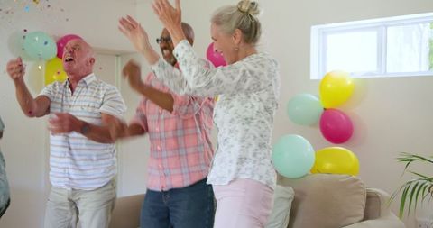 Elderly Friends Dancing with Joy at Home Celebration