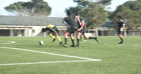 Enthusiastic soccer players practicing teamwork on field