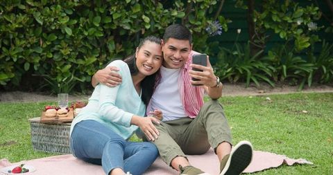 Smiling Couple Taking Selfie During Outdoor Picnic in Garden