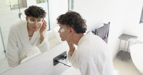 man applying under-eye gel patches for refreshing skin care routine - Download Free Stock Images Pikwizard.com