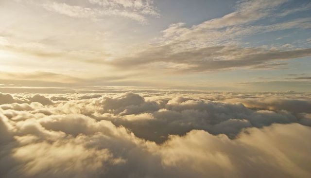 Golden Dawn Over Layered Clouds at High Altitude, Aerial Sky Horizon with Cirrus Streaks