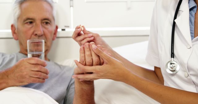 Nurse giving pills to mature man lying on a bed at hospital - Download Free Stock Photos Pikwizard.com