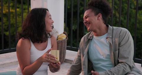 Couple Joyfully Sharing Snacks on Patio During Wedding Celebration
