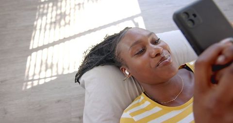 Relaxed Young Woman Enjoying Smartphone Music at Home