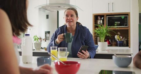 Happy Lesbian Couple Enjoying Breakfast with Daughter at Home
