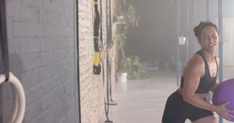 Woman Engaged in Fitness with Exercise Ball in Gym Setting