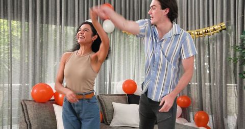 Couple Joyfully Dancing at Birthday Celebration in Living Room