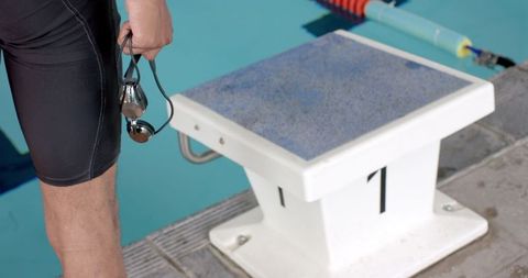 Swimmer preparing for dive at competitive pool start