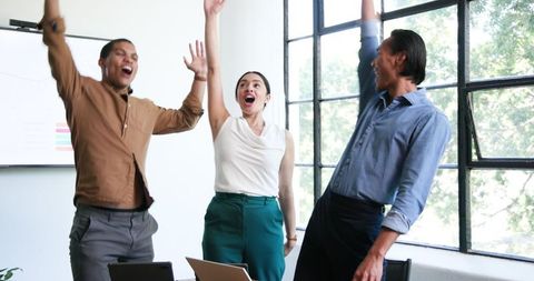 Diverse Team Celebrating Office Success with High Energy