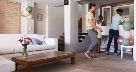 Friends Preparing Home Celebration with Balloons and Drinks