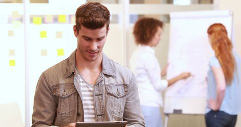 Young Professional Using Tablet in Collaborative Office Environment - Download Free Stock Images Pikwizard.com