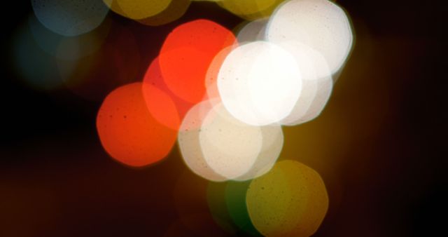 Blurred multicolored bokeh lights form abstract, appealing patterns against a dark background. Ideal for use in festive greetings, event invitations, and as eye-catching backgrounds for various digital and print projects to evoke a sense of warmth and celebration.