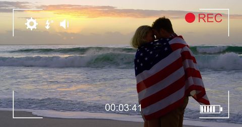 Romantic Sunset Beach Scene with Couple Wrapped in American Flag