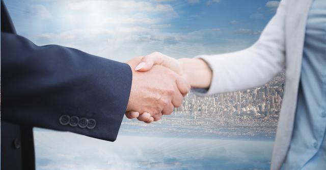 Business professionals shaking hands, symbolizing partnership and cooperation, with a city background. Perfect for themes related to corporate meetings, successful collaborations, and business agreements. Ideal for use in business presentations, company websites, and promotional materials focused on networking and partnerships.