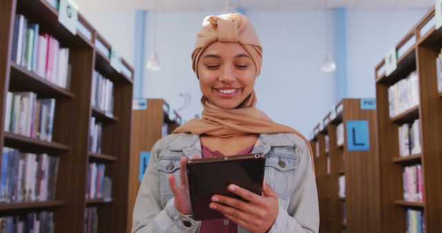 Smiling Woman Reading on Tablet in Library - Download Free Stock Images Pikwizard.com