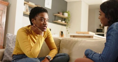 Diverse Women Chatting Casually on Sofa in Modern Living Room