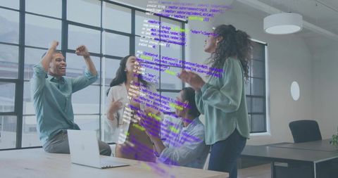 Startup team celebrating milestone around conference table with laptop and code overlay