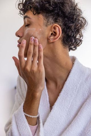 Man in Bathrobe Applying Facial Cream Daily Self-Care Routine