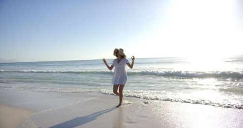 Serene Beach Walk with Sunhat and White Dress